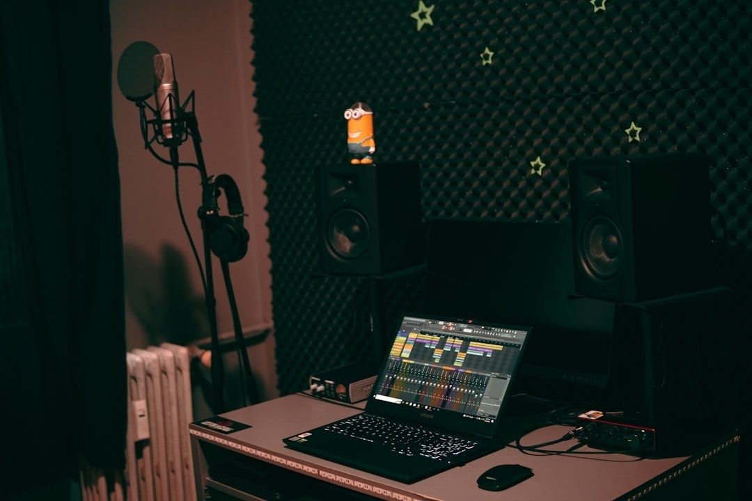 Hemmastudio med mikrofon, hörlurar, högtalare och laptop