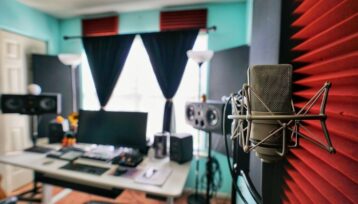 Hemmastudio med mikrofon, högtalare och röd ljudabsorberande vägg