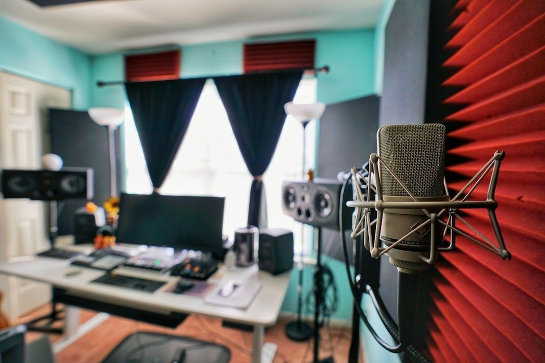 Hemmastudio med mikrofon, högtalare och röd ljudabsorberande vägg
