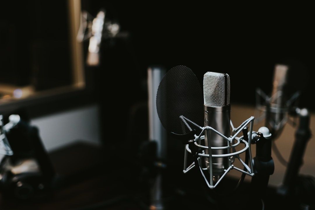 Kondensatormikrofon med popfilter i en mörk podcaststudio